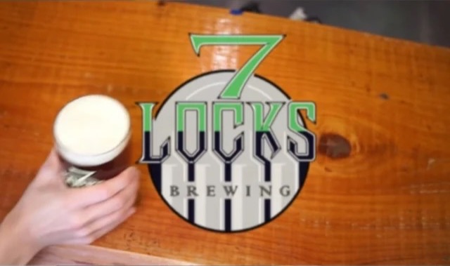 A fresh 7 Locks pint with a thick head of foam beside the brewery logo